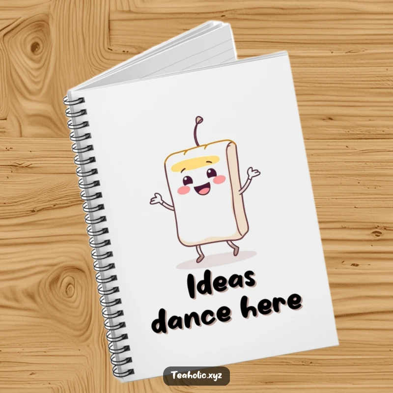 Funny smiling teabag character doing a lively jig on the cover of a lined notebook.